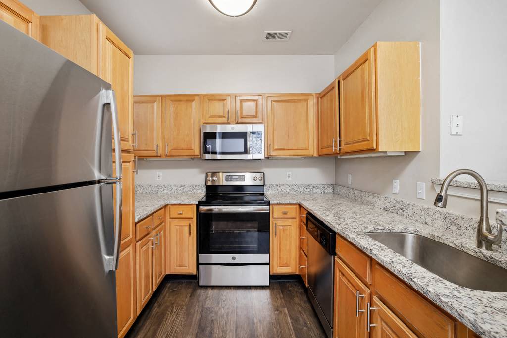 a kitchen with wooden cabinets and stainless steel appliances