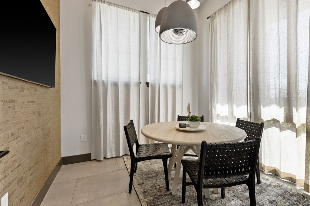 a dining room with a table and chairs and a large window