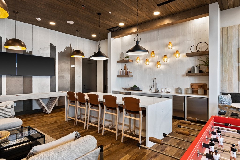 a living room with a kitchen and a table with chairs
