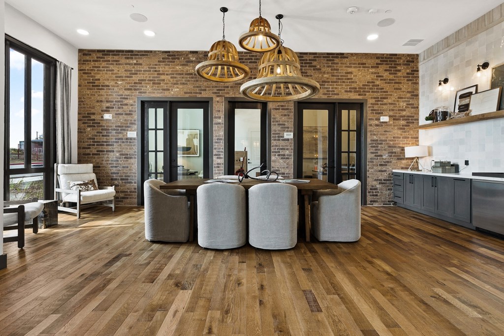 a living room with a table and chairs and a brick wall