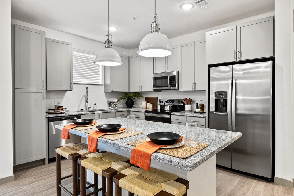 a kitchen with stainless steel appliances and a marble counter top