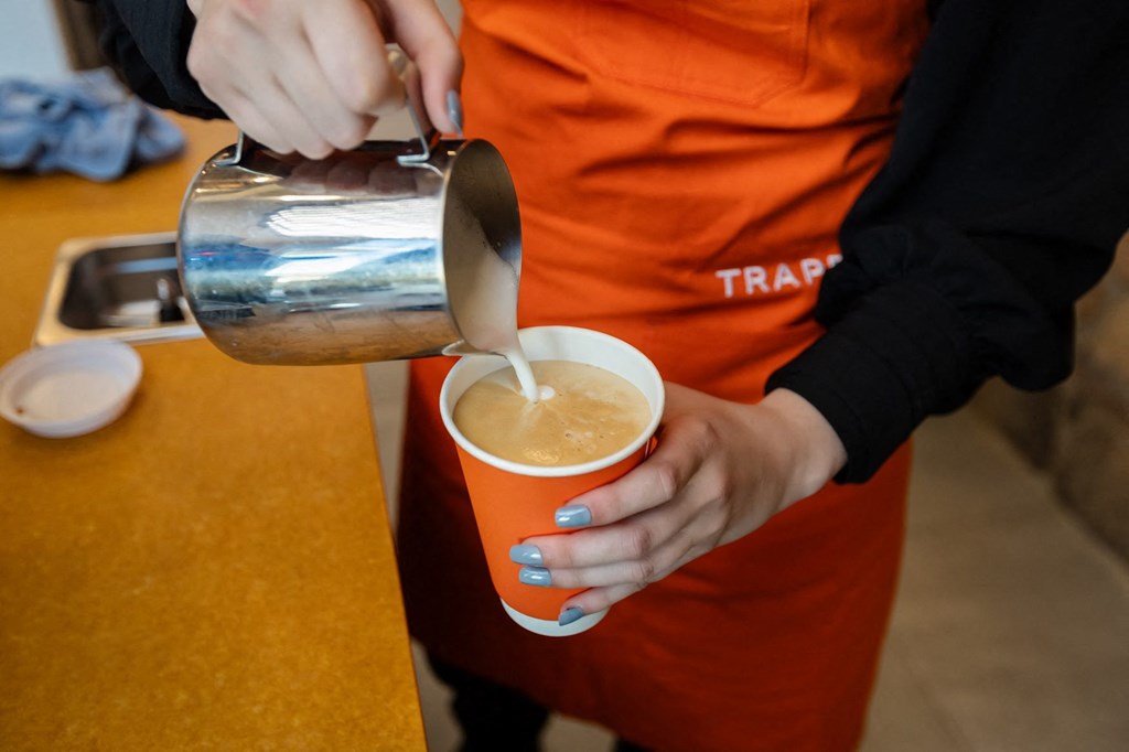 a person is pouring coffee into a cup