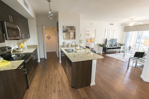 A kitchen with dark wood cabinets and granite countertops.