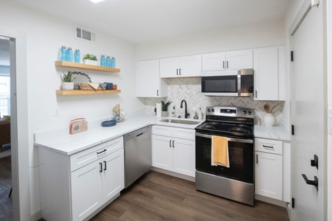 A kitchen with white cabinets and a black stove top oven.