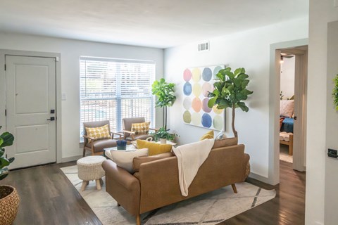 A living room with a brown couch and a white blanket on it.