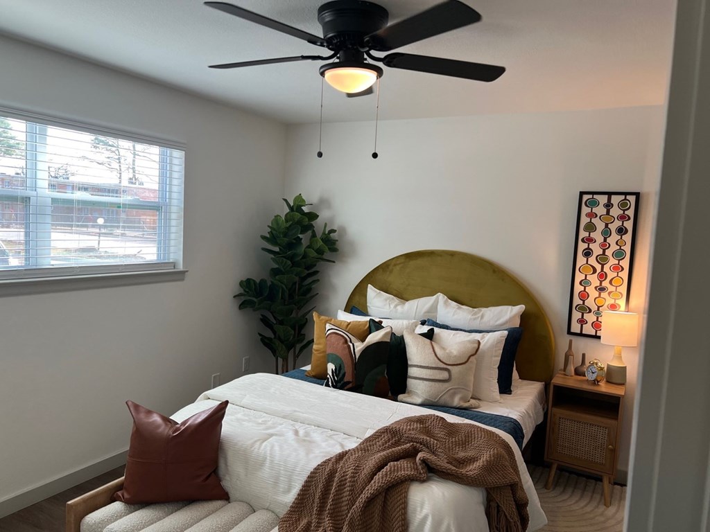 A bedroom with a bed, a ceiling fan, and a plant. A bedroom with a bed, a ceiling fan, and a plant.at Century Apartments, Memphis Tennessee