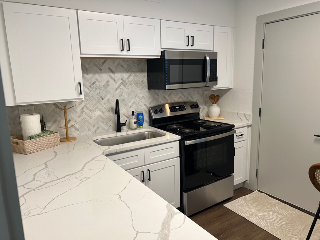 A kitchen with white cabinets and a black stove top oven. A kitchen with white cabinets and a black stove top oven.at Century Apartments, Memphis