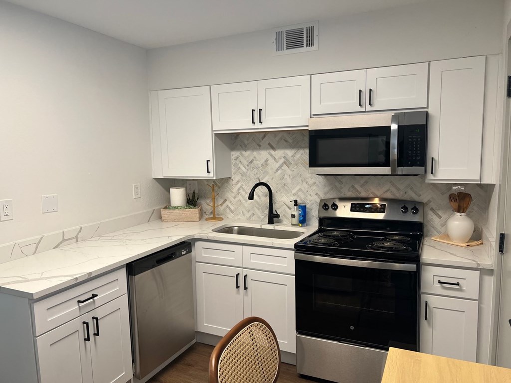 A kitchen with white cabinets and a black stove top oven. A kitchen with white cabinets and a black stove top oven.at Century Apartments, Memphis, 38117