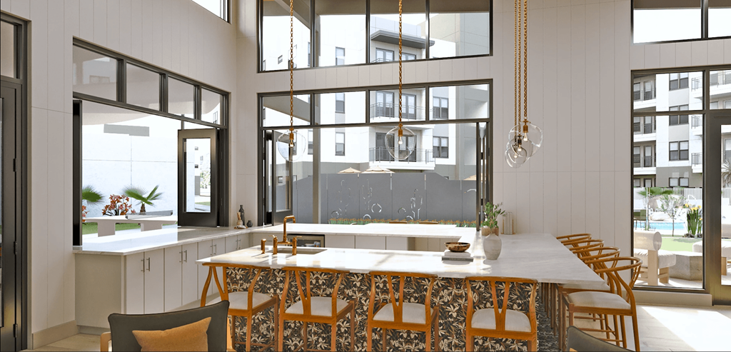 a kitchen with a long counter and chairs in front of large windows at Livano Avondale, Avondale, AZ