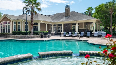 A pool with a house in the background.