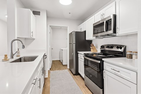 A kitchen with white cabinets and appliances.