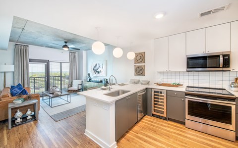 a kitchen and living room with a sink and a microwave