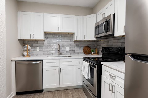 A kitchen with white cabinets at Dunwoody Glen, Georgia
