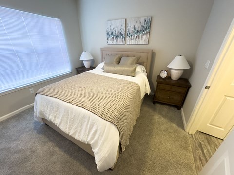 A bedroom with a large bed and two nightstands.