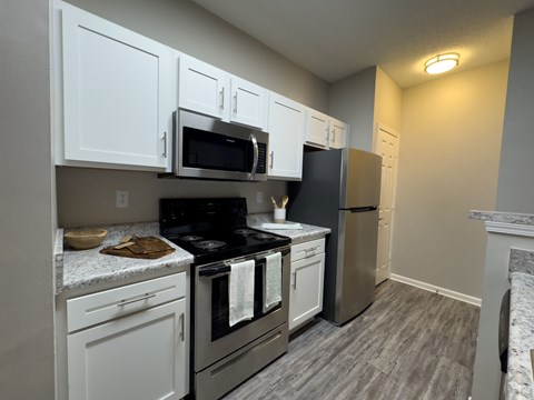A kitchen with white cabinets and a black stove top.