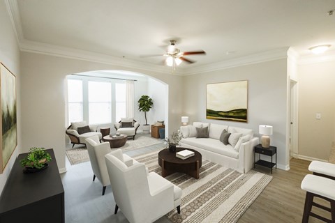 A living room with a white couch, a coffee table, and a painting on the wall.