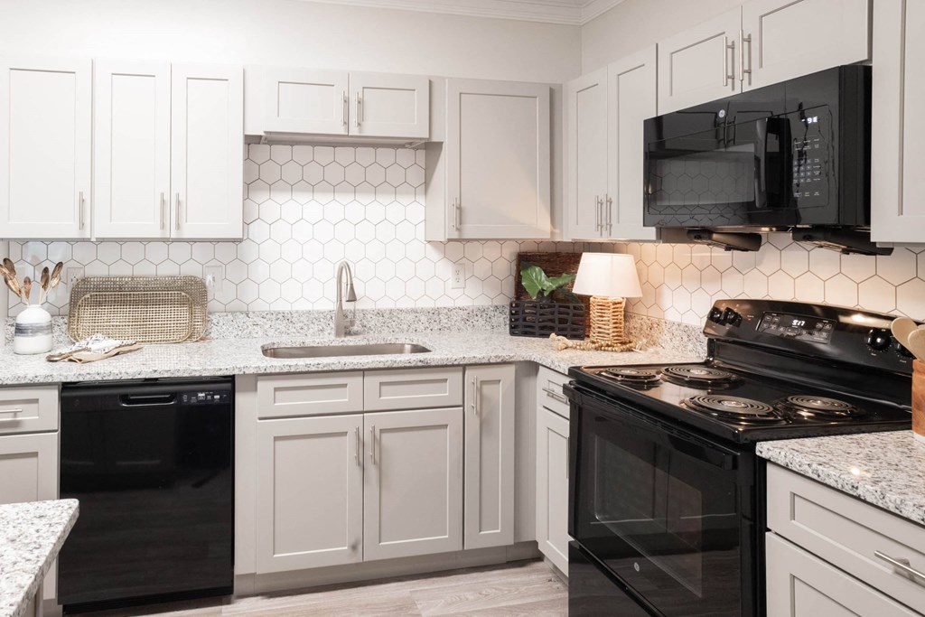 a kitchen with white cabinets and black appliances at Appling Lakes, Cordova, TN
