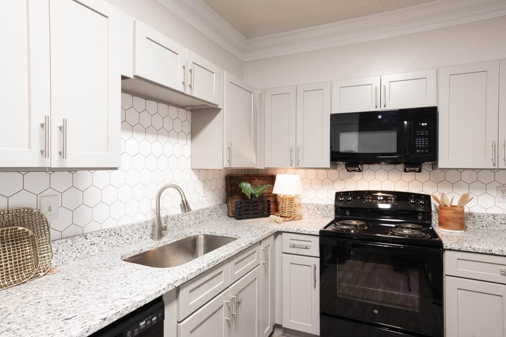 a kitchen with white cabinets and black appliances at Appling Lakes, Cordova, 38016
