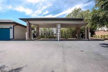 A parking lot with a covered parking area and a blue garage door at Park Place Oviedo Apartments, Oviedo, 32765