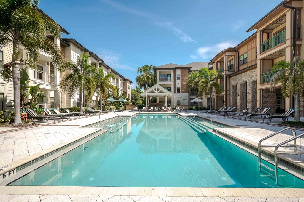 A large swimming pool in the middle of a resort surrounded by palm trees A large swimming pool in the middle of a resort surrounded by palm trees at Park Place Oviedo Apartments, Oviedo, 32765