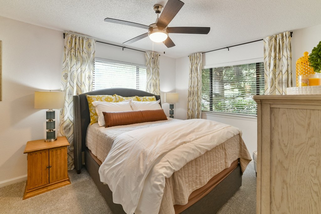 a bedroom with a bed and a ceiling fan