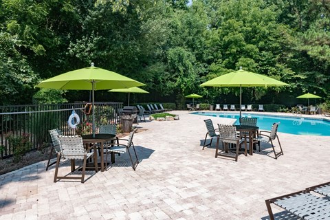 a patio with tables and umbrellas next to a swimming pool at 1900 Rosemont, Georgia