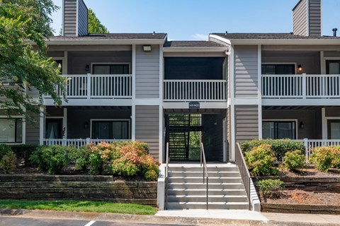 front view of an apartment building with stairs and balconies at 1900 Rosemont, Roswell, 30076