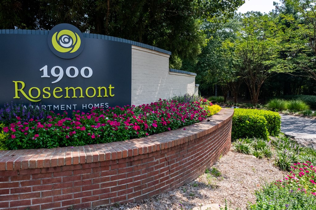 a brick retaining wall with a sign for rosenmont apartment homes