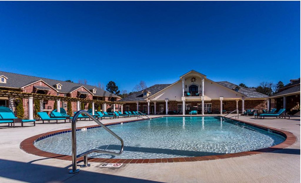 a resort style pool with lounge chairs around it  at Arlo Luxury homes Apartments, Arkansas