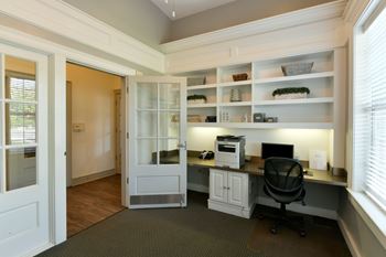 A home office with a desk, chair, and shelves.