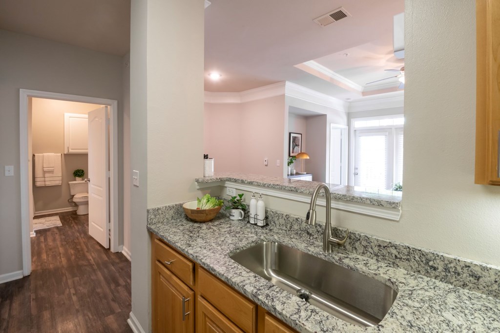A kitchen with a granite countertop and a stainless steel sink. at Cambridge Square, Overland Park, Kansas