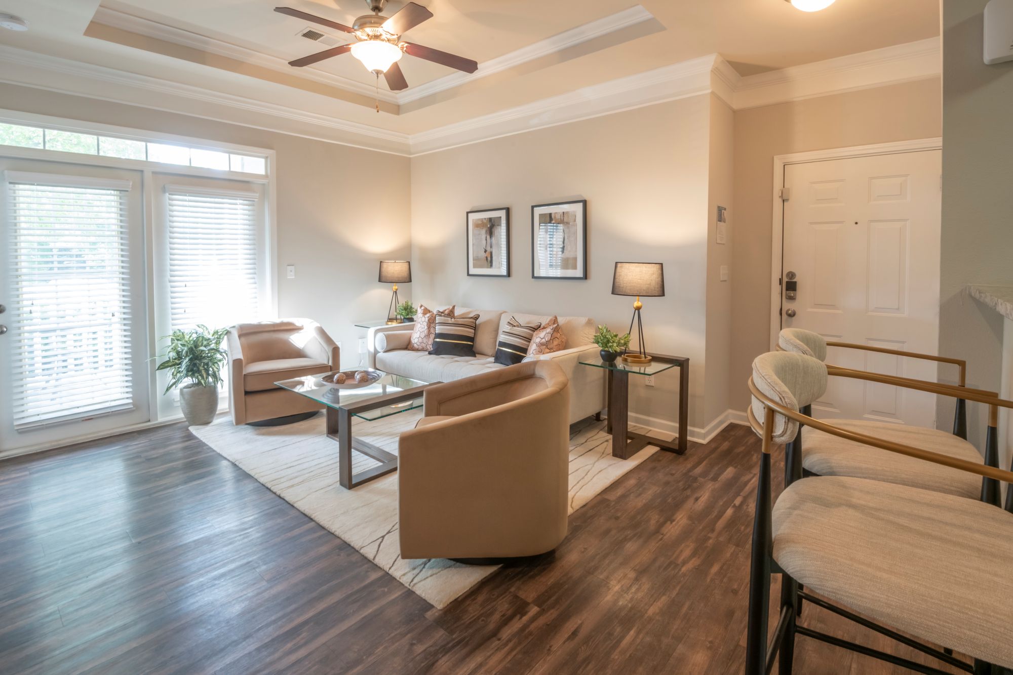 A living room with a brown sofa and a wooden floor.