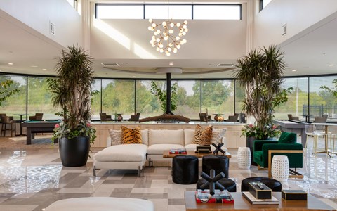the lobby of a hotel with a couch and chairs and large windows the lobby of a hotel with a couch and chairs and large windows at Esplanade District Apartments, Little Rock, AR,72114