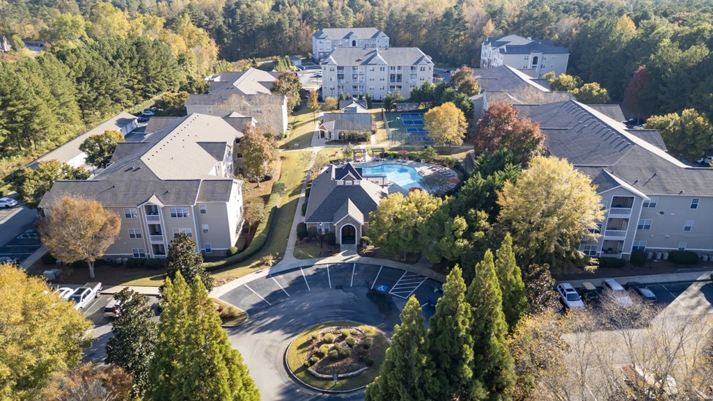 A bird's eye view of a residential area with houses and a swimming pool.