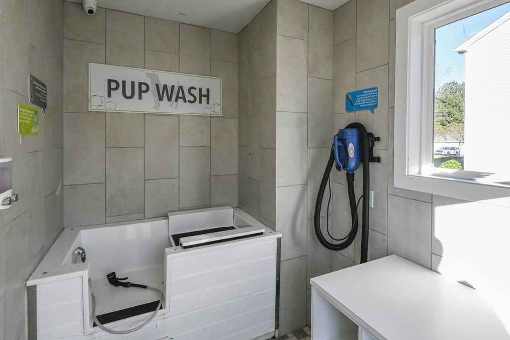 A white sink and a sign that says PUP WASH.