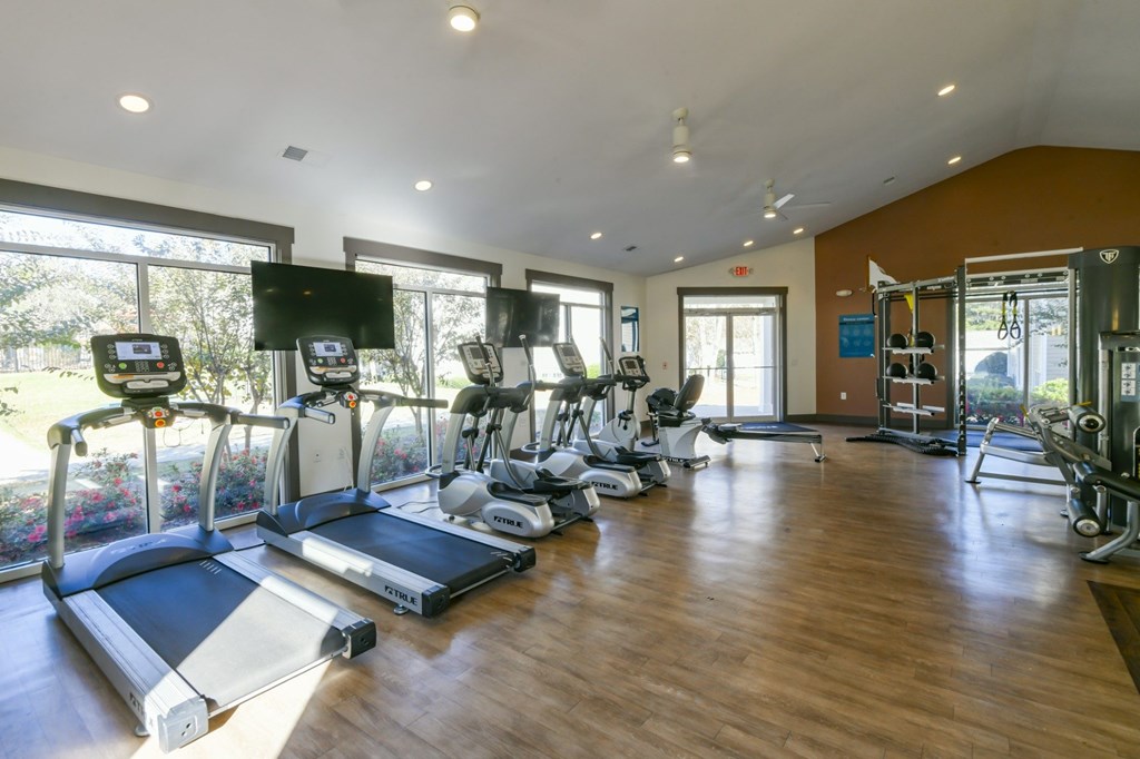 A gym with treadmills, elliptical machines, and other exercise equipment.