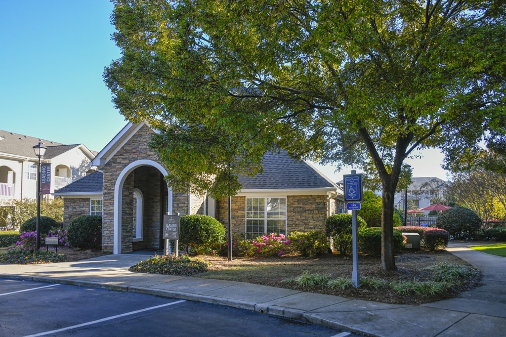 A parking sign is on a pole in front of a building.