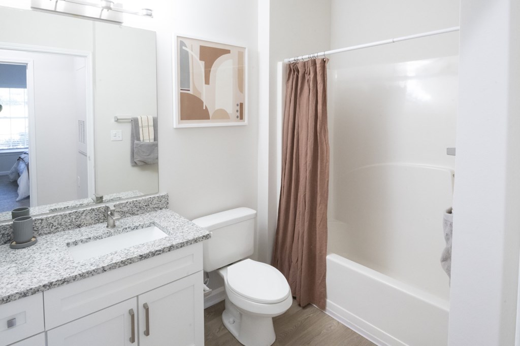 A bathroom with a toilet, sink, and shower.