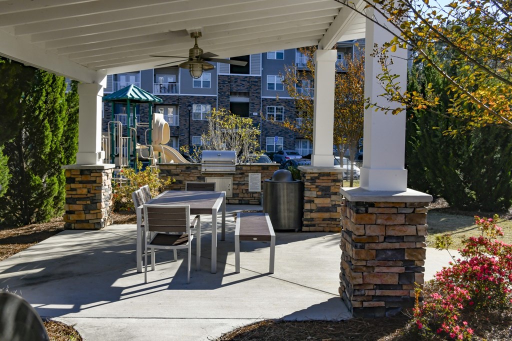 A patio with a table and chairs under a roof.