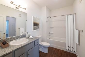 A bathroom with a white sink, toilet, and bathtub.