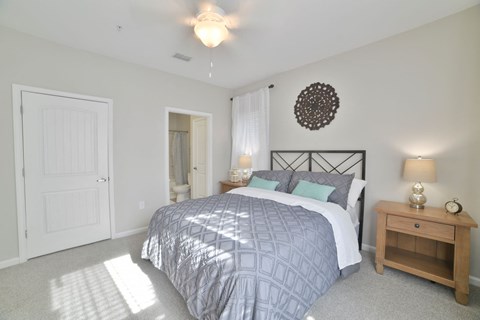 a bedroom with a bed and a door to a bathroom at Legends at Chatham Apartments, Savannah