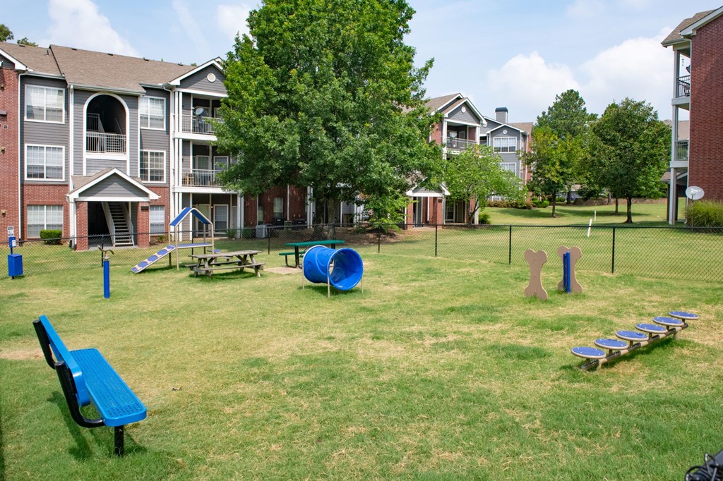 a large grassy area with a playground and picnic tables in front of an apartment complex at Lincoln at Wolfchase, Cordova