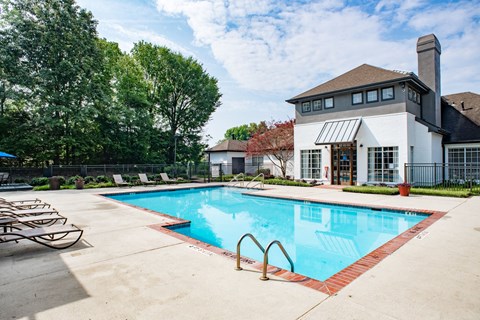 a swimming pool with lounge chairs and a building in the background at Lincoln at Wolfchase Apartments, Tennessee