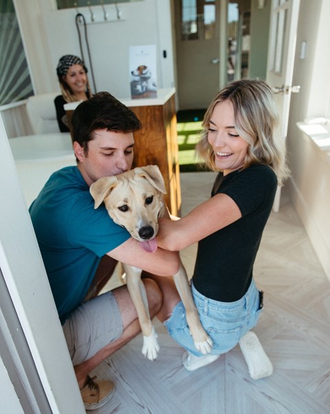 a man and a woman holding a dog in a bathroom at Livano Springdale, Louisville Kentucky