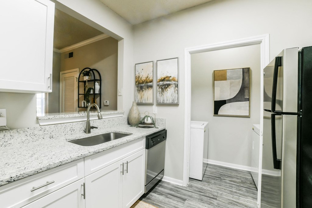 A kitchen with a black refrigerator and white cabinets. at Madison Shelby Farms, Memphis