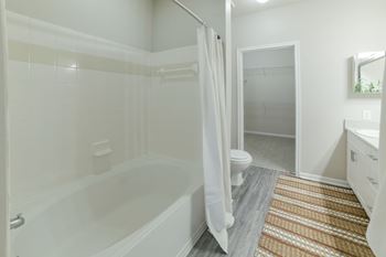 A white bathroom with a tub, toilet, and sink. at Madison Shelby Farms, Memphis, Tennessee