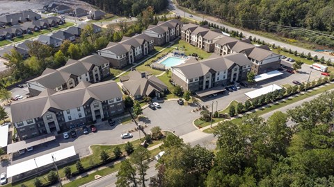 A bird's eye view of a residential complex with multiple houses and a pool.