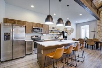 A modern kitchen with a large island and stainless steel appliances.