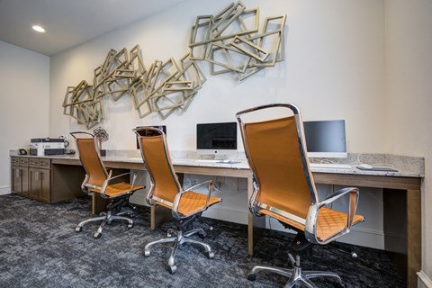 Three chairs are in front of a desk with a computer.