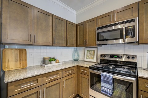 A kitchen with wooden cabinets and a stove top oven.